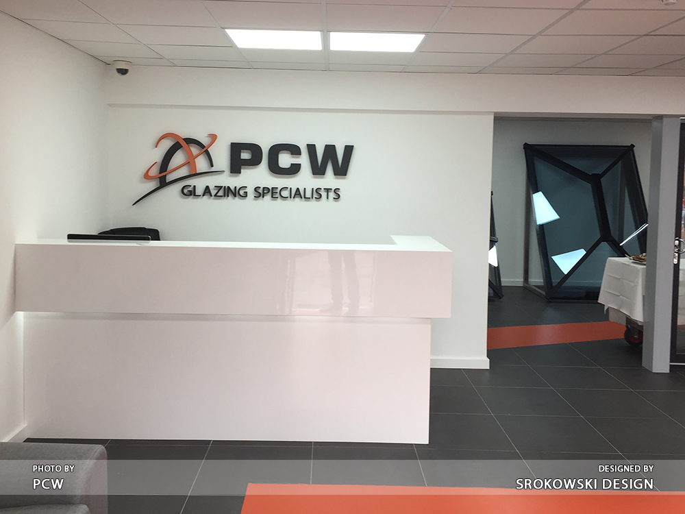 Reception desk with PCW Glazing Specialists logo wall